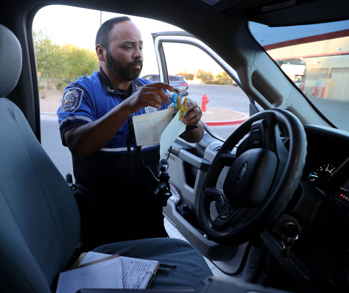 North Las Vegas Police Officer Andy Navarro separates drivers' information at the scene of a cr ...