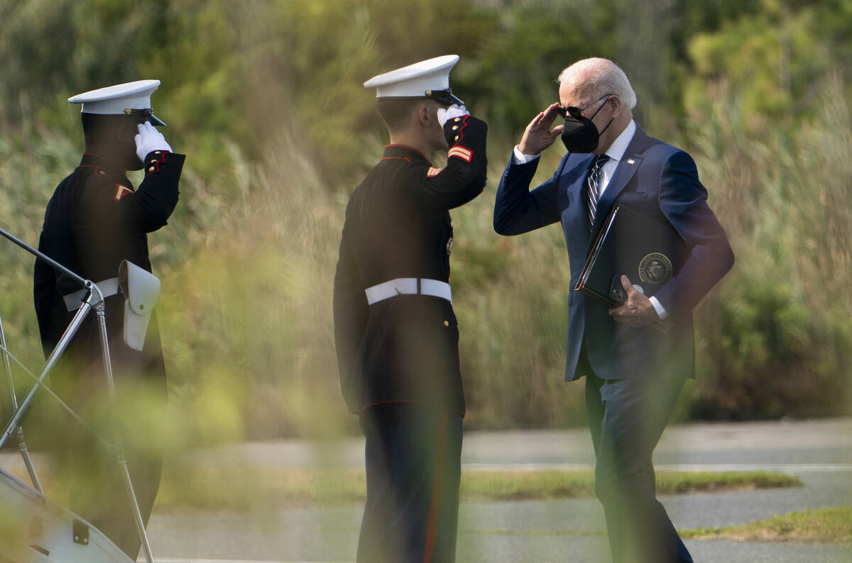 President Joe Biden returns a salute to a Marine Corps honor guard as he walks to board Marine ...