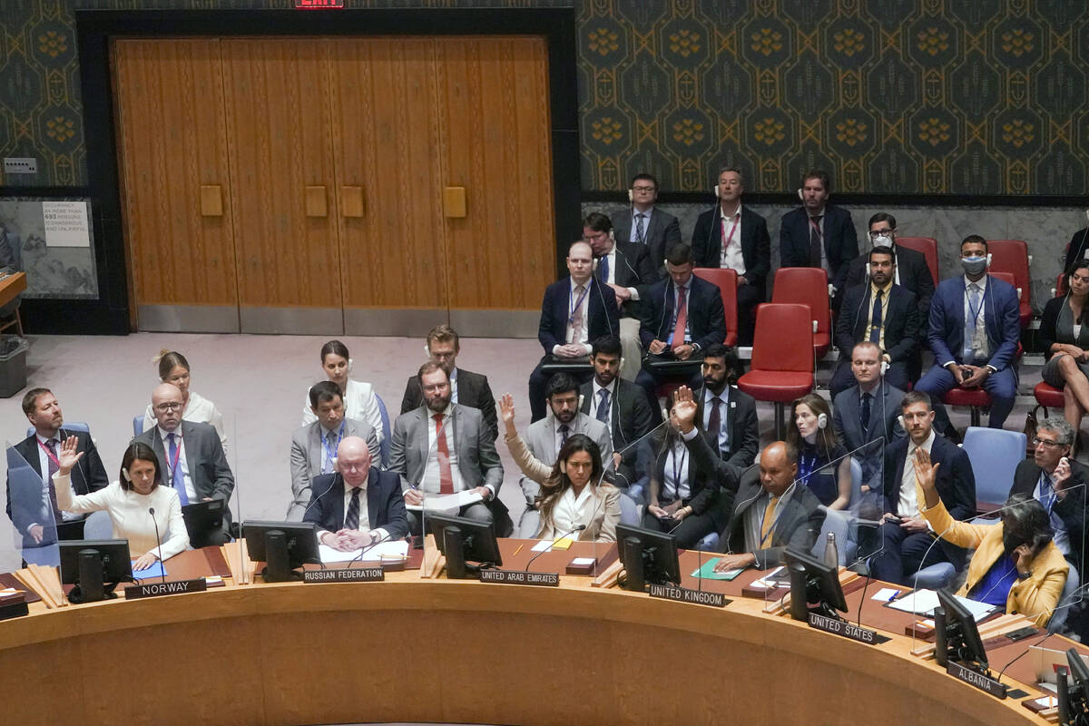 FILE - Members of the United Nations Security Council conduct a procedural vote on whether to a ...