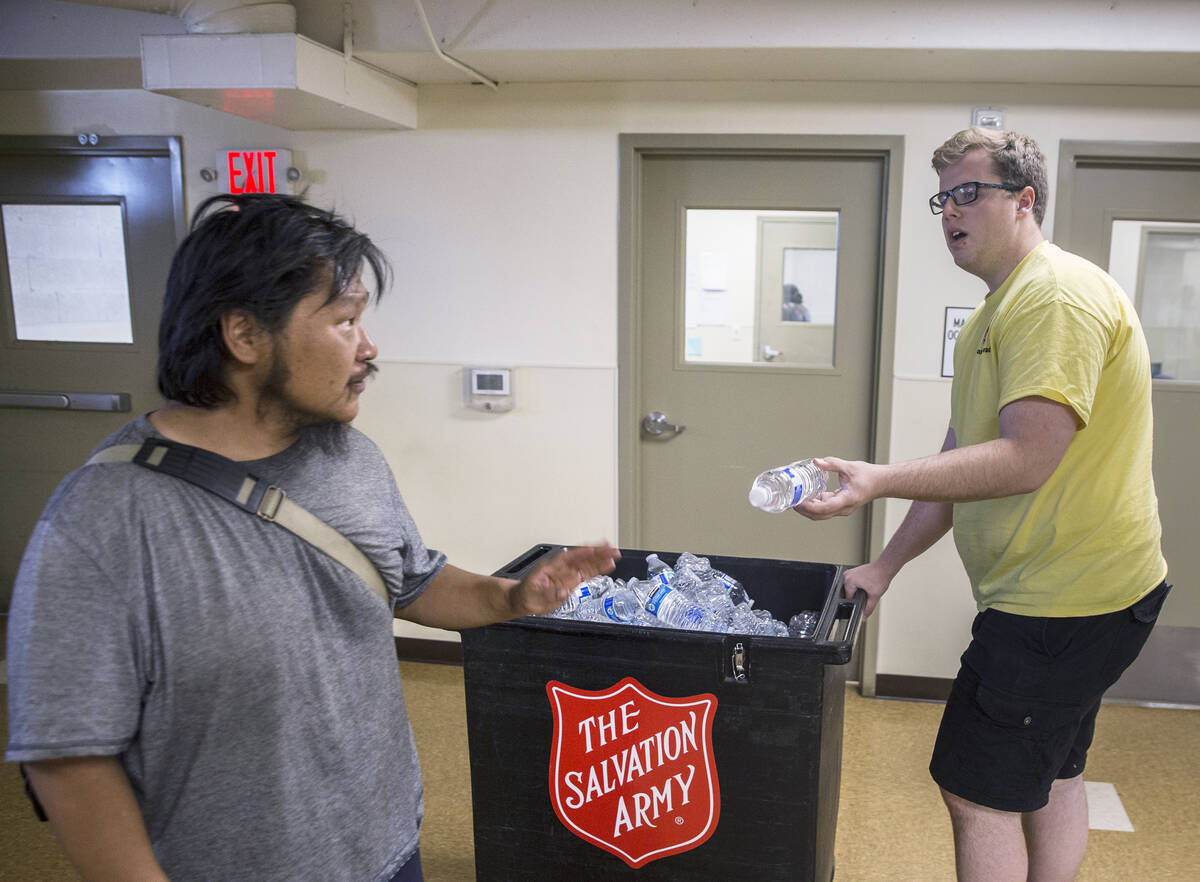 Shelter monitor Boston Brimhall, right, hands out water at a cooling station at The Salvation A ...