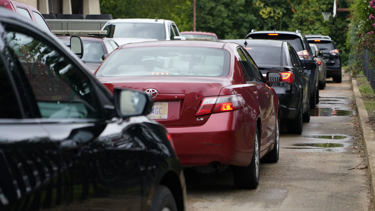 Area residents line up at the city's downtown fire station to receive bottled water, Aug. 18, 2 ...