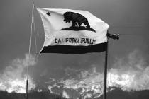 The California state flag flies next to a home on Highway 94 south Potrero, Calif., on Monday, ...