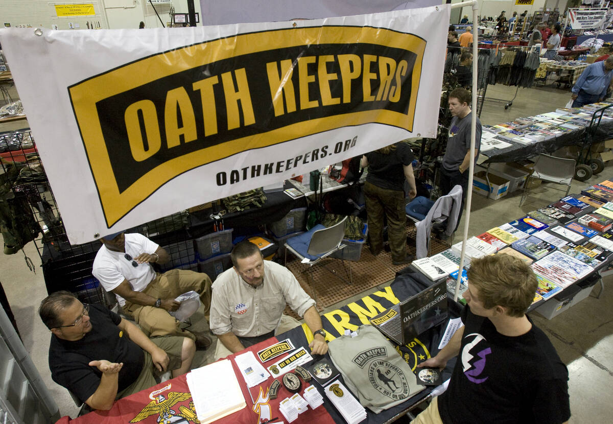 Stewart Rhodes, founder and spokesman of the Oath Keepers, left, talks to Kyle Zortman, 17, of ...