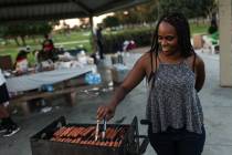 Shotoya Crane grills hotdogs during a Labor Day barbecue at Lorenzi Park in Las Vegas, Monday, ...