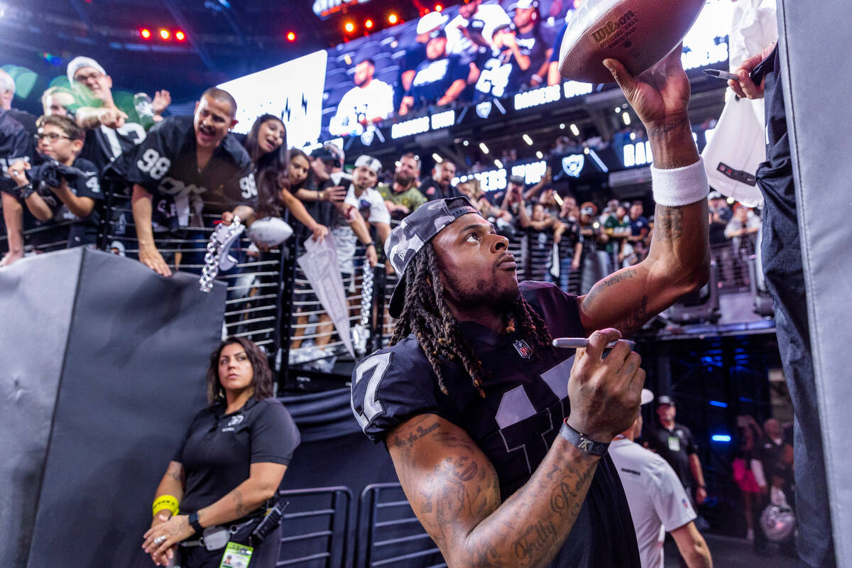 Raiders wide receiver Davante Adams (17) hands back an autographed ball to a fan after defeatin ...