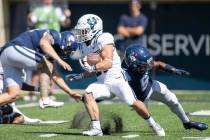 Utah State Aggies running back Cooper Jones (31) avoids the tackle from Connecticut Huskies def ...