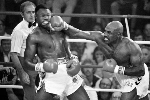 FILE - Challenger Earnie Shavers drives a right hand to the head of heavyweight champion Larry ...