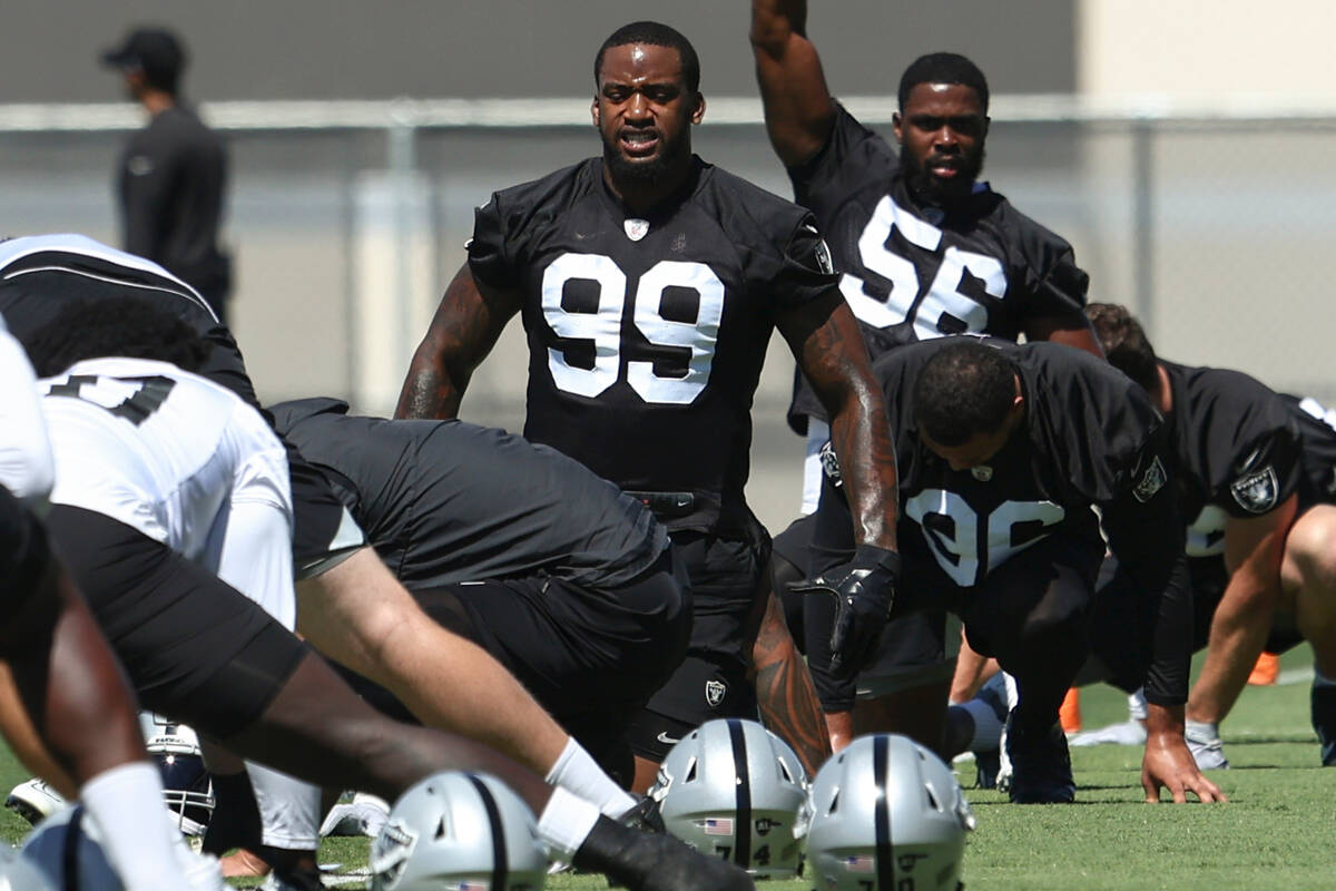 Raiders defensive ends Clelin Ferrell (99) and Gerri Green (56) stretch during practice at Raid ...