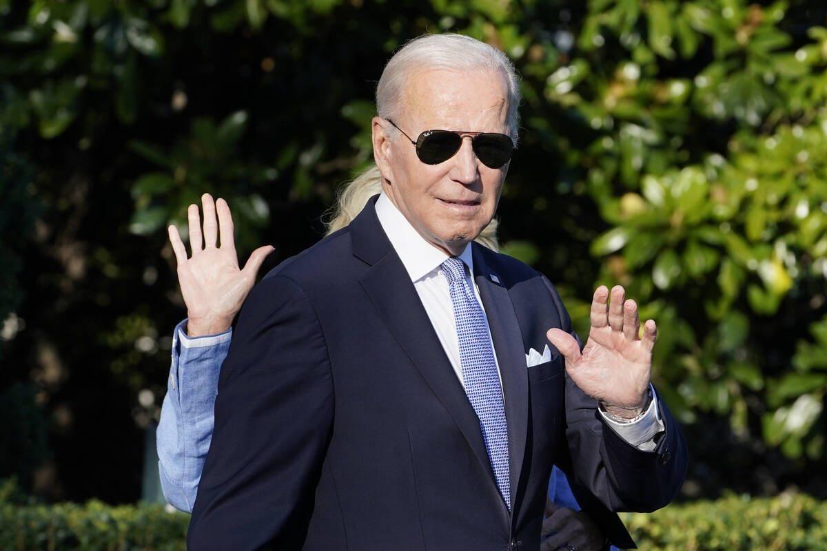 President Joe Biden and first lady Jill Biden, hidden, wave as they walk towards Making One on ...