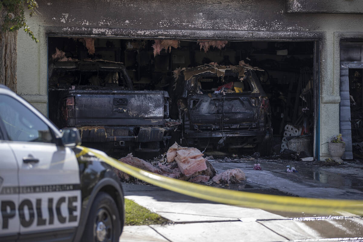 Metropolitan police remain at the scene of a house fire that was extinguished by fire crews in ...