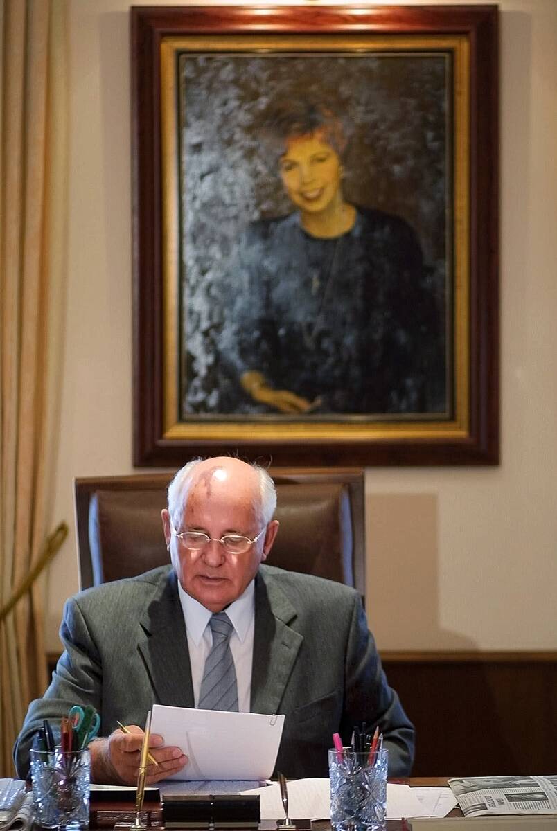 FILE - Former Soviet President Mikhail Gorbachev reads some notes in his office with a portrait ...