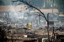 Firefighters survey homes on Wakefield Avenue destroyed by the Mill Fire on Saturday, Sept. 3, ...