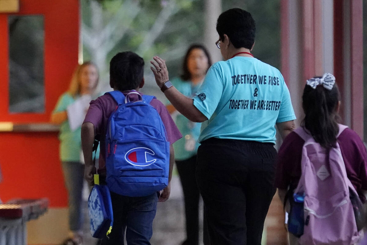 Students arrive at Uvalde Elementary, now protected by a fence and Texas State Troopers, for th ...