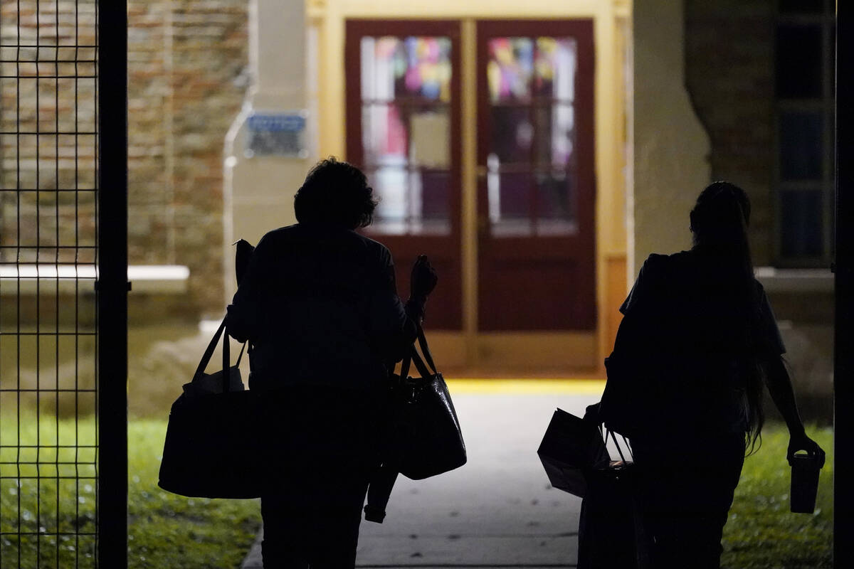 Teachers walk through the gate of a new fence as they arrive at Uvalde Elementary for the first ...