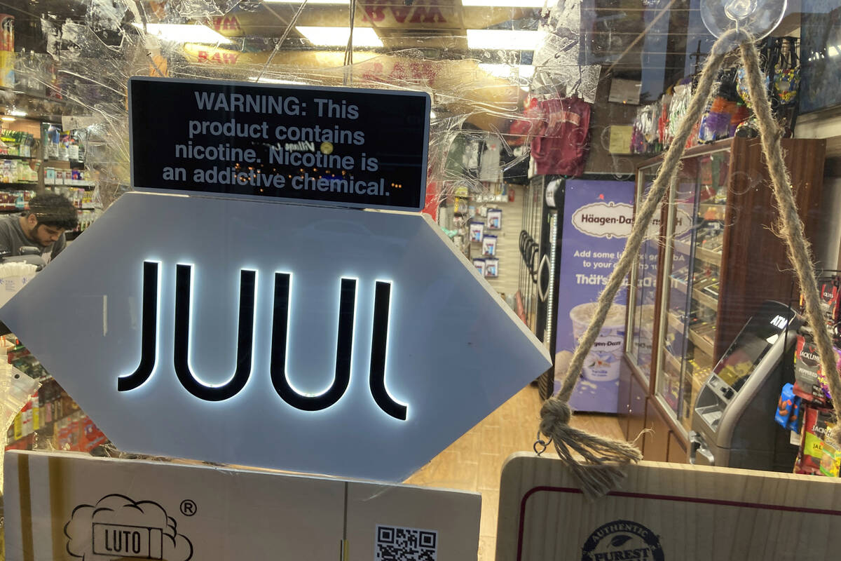 FILE - A Juul electronic cigarette sign hangs in the front window of a bodega convenience store ...