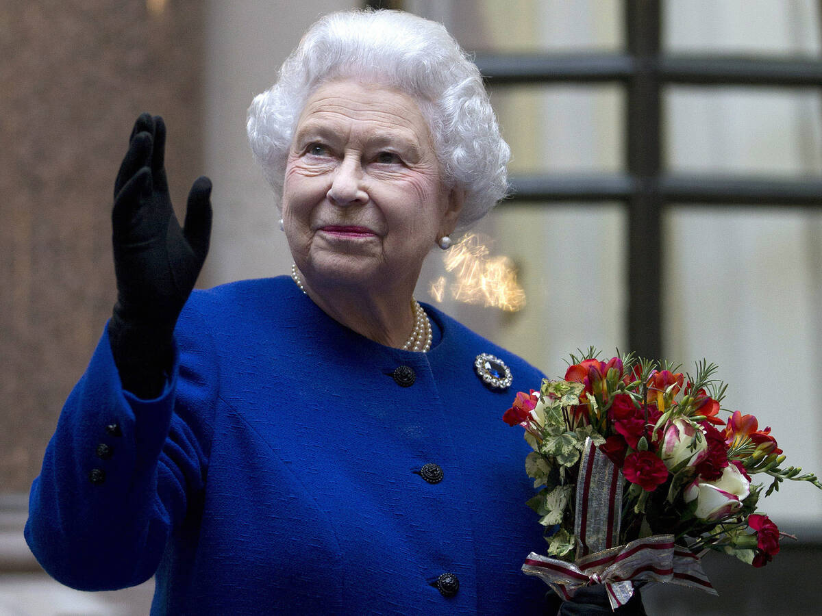 In this Tuesday, Dec. 18, 2012 file photo, Britain's Queen Elizabeth II looks up and waves to m ...