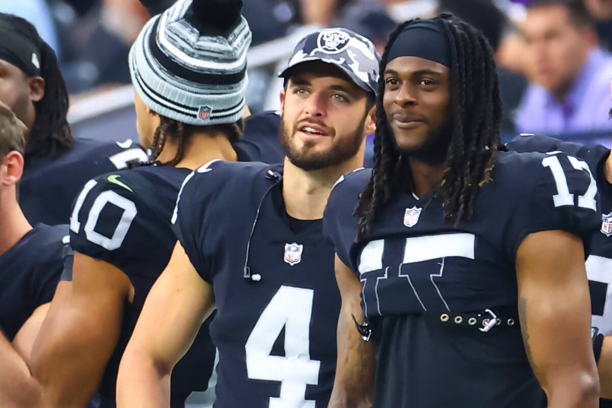 Raiders quarterback Derek Carr (4) and wide receiver Davante Adams look on during the second ha ...