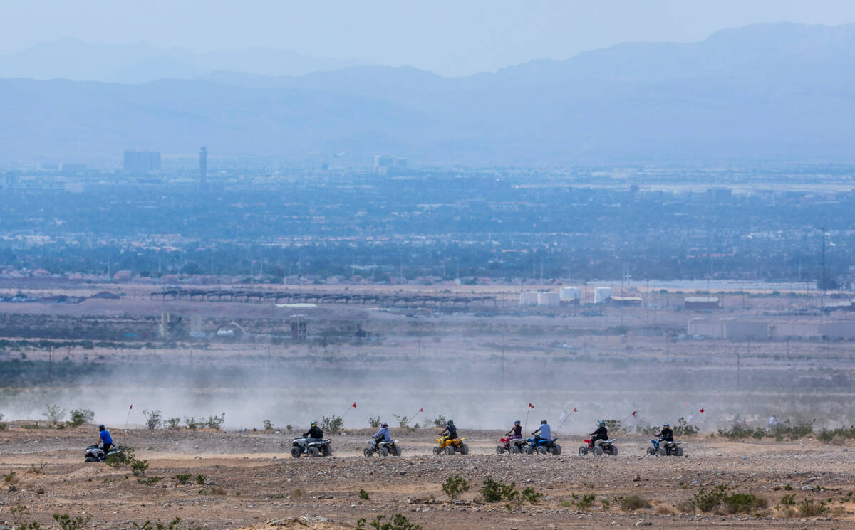 Dust kicks up as ATV riders cruise along a ridge south of Apex as the Clark County Department o ...