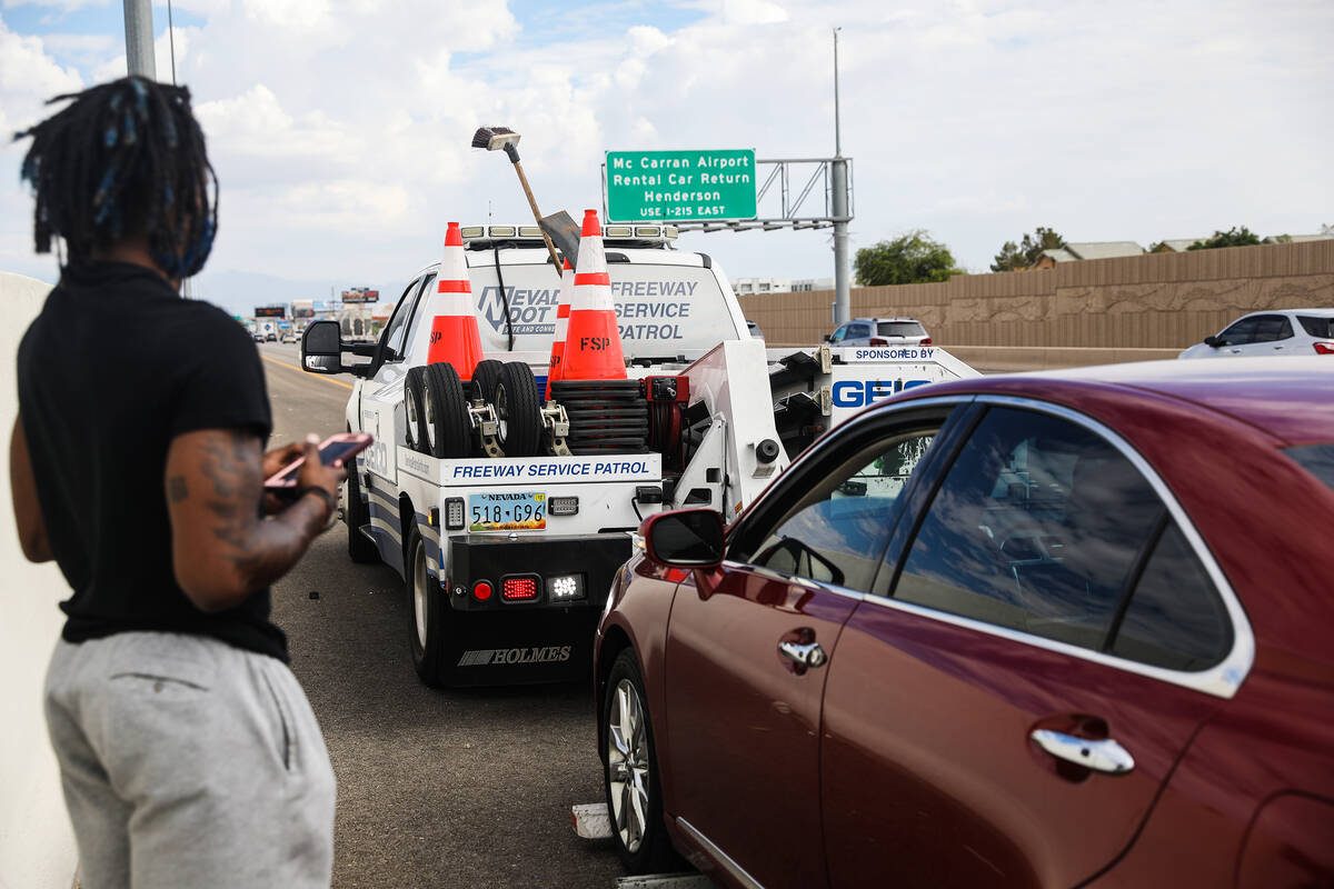 Jonathan Braggs looks on as his broken car is towed on the I-15 in Las Vegas, Tuesday, Sept. 13 ...