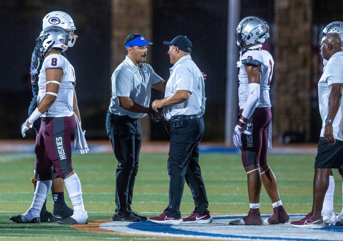 Bishop Gorman head coach Brent Browner, left, talks with Hamilton head coach Michael Zdebski f ...