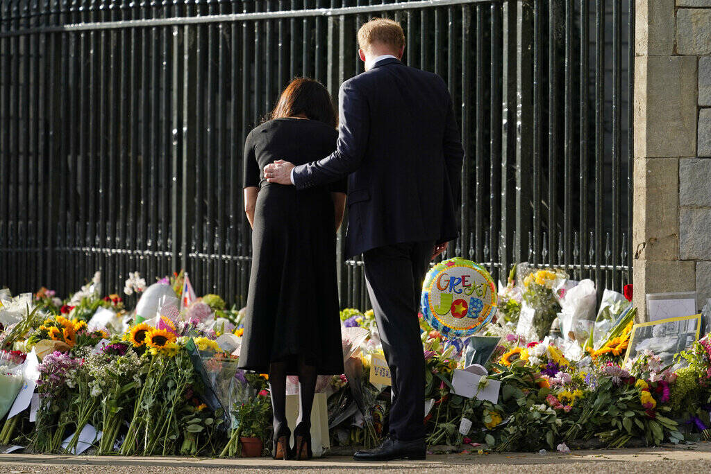 Britain's Prince Harry and Meghan, Duchess of Sussex view the floral tributes for the late Quee ...