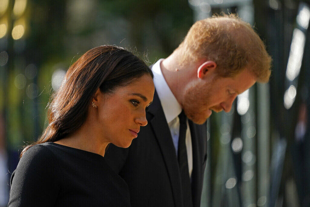 Britain's Prince Harry and Meghan, Duchess of Sussex view the floral tributes for the late Quee ...