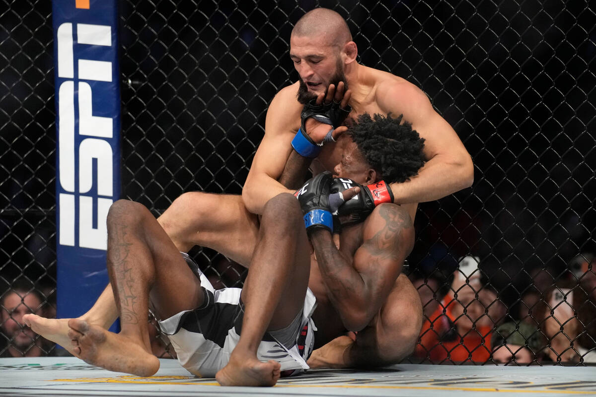 Khamzat Chimaev, top, fights Kevin Holland in a 180-pound catchweight bout during the UFC 279 m ...