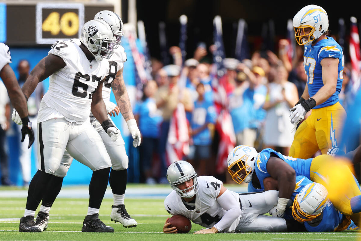 Raiders quarterback Derek Carr (4) is sacked by Los Angeles Chargers defensive tackle Sebastian ...