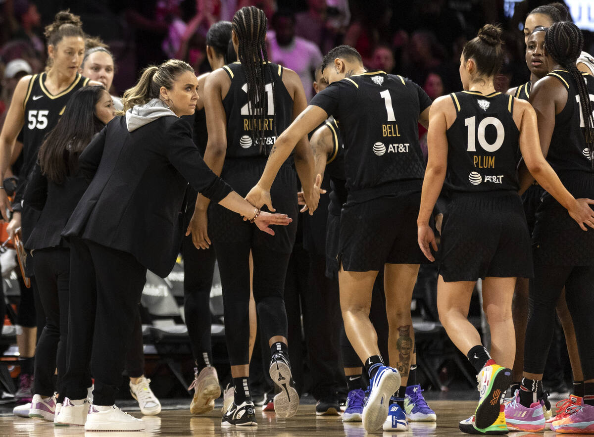 Las Vegas Aces head coach Becky Hammon slaps hands with her team before rotating the starters o ...