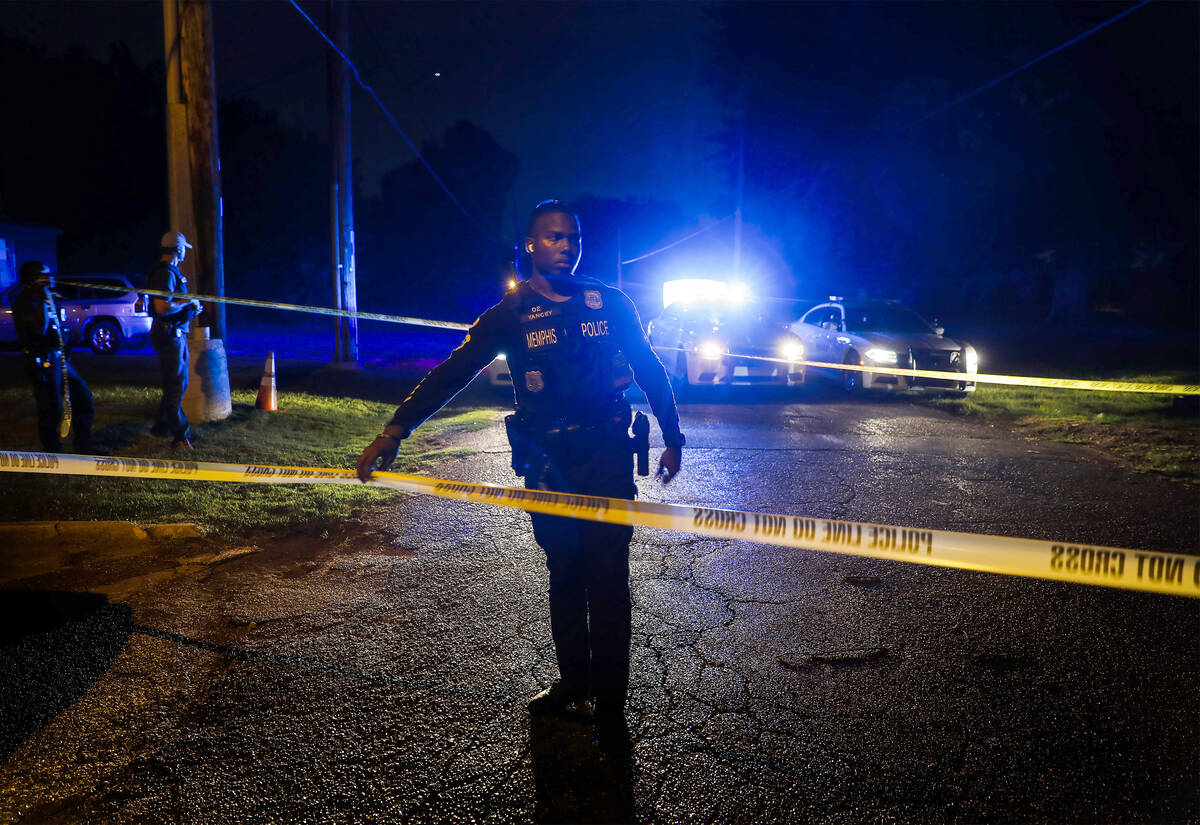 Memphis police officers search an area where a body had been found in South Memphis, Tenn., nea ...