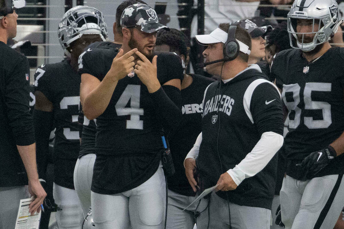 Raiders quarterback Derek Carr (4) has a discussion with head coach Josh McDaniels during the f ...