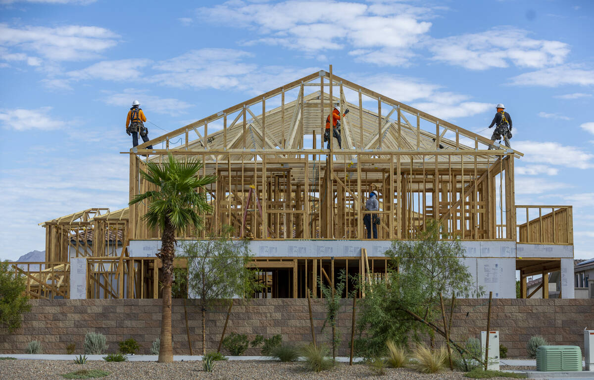 A construction crew works on the Fram of a new house within The McAuley far east on Galleria Dr ...