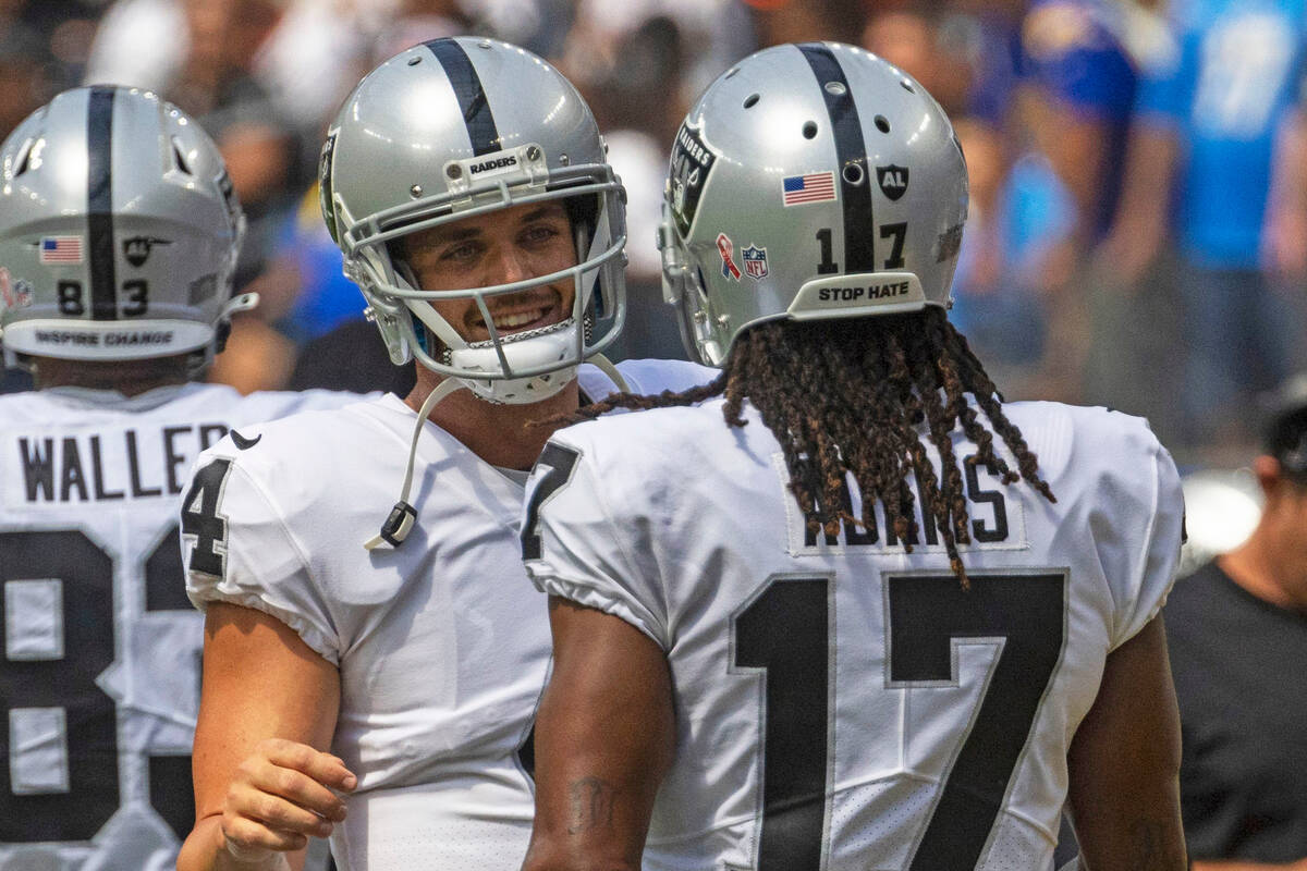 Raiders quarterback Derek Carr (4) and Raiders wide receiver Davante Adams (17) meet on the sid ...