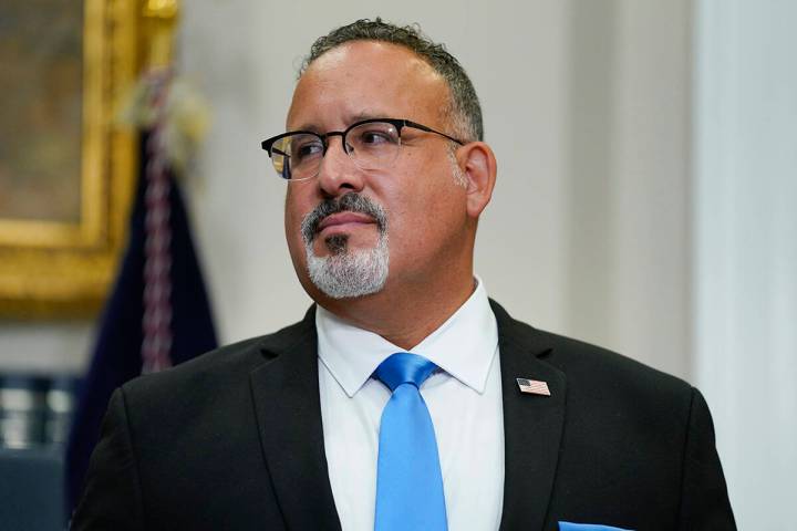 Education Secretary Miguel Cardona listens as President Joe Biden speaks about student loan deb ...