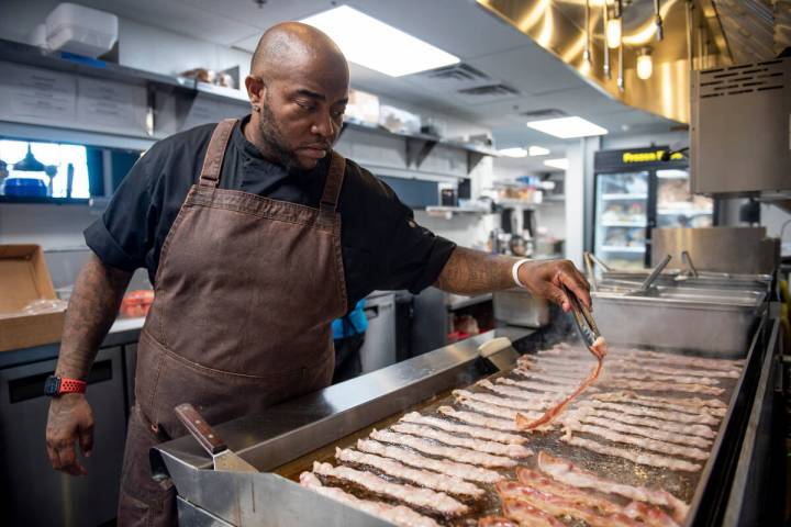 Chef Vincent Watts flips bacon on the grill at Street Burger on Friday, Sept. 16, 2022, in Hend ...