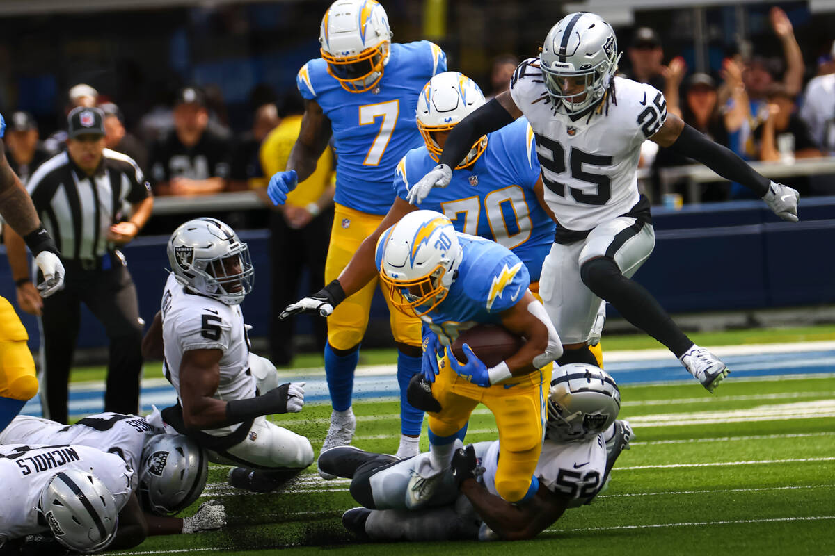 Raiders linebacker Denzel Perryman (52) takes down Los Angeles Chargers running back Austin Eke ...