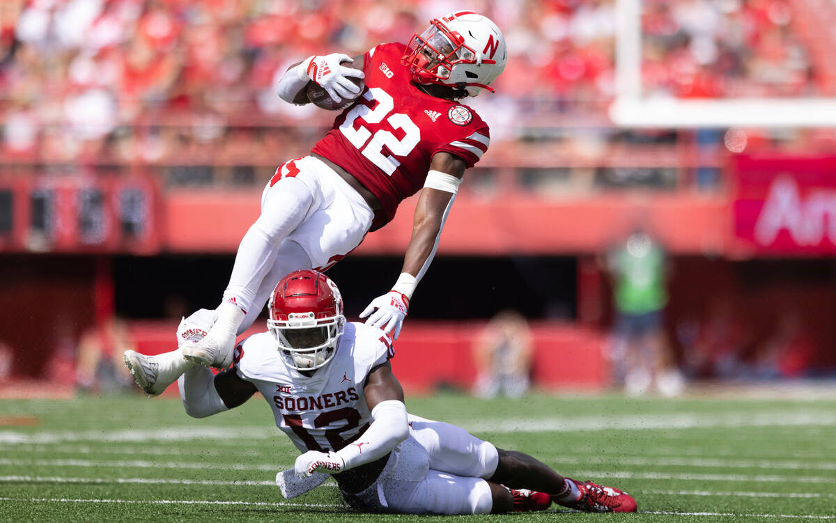 Nebraska's Gabe Ervin Jr. (22) gets tripped up by Oklahoma's Key Lawrence (12) during the secon ...