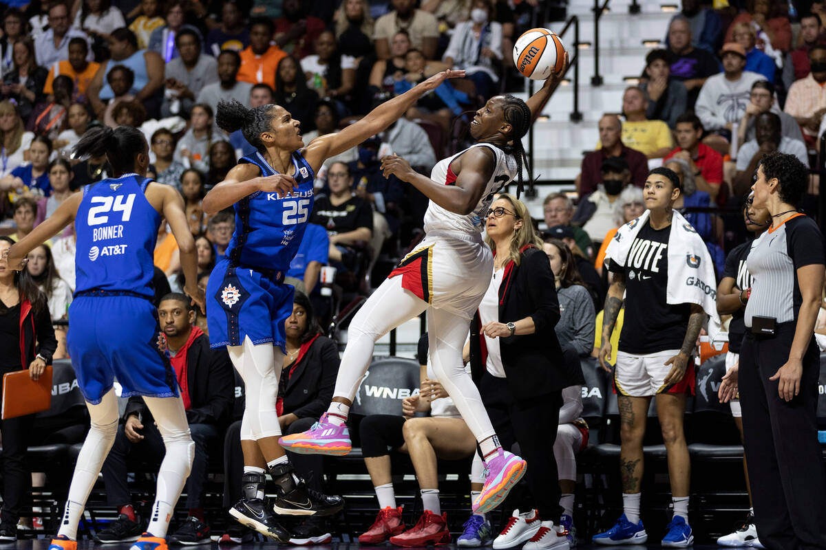 Las Vegas Aces guard Chelsea Gray (12) jumps to pass while Connecticut Sun forward Alyssa Thoma ...