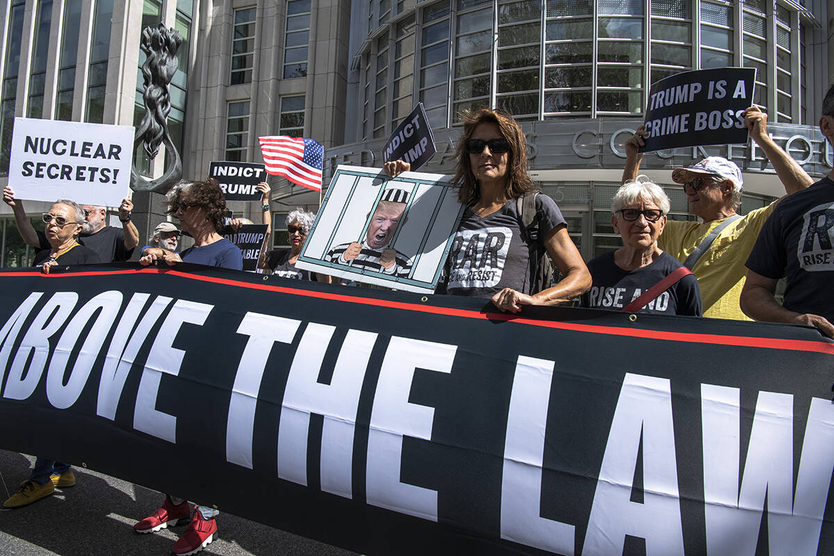 Protesters stand outside as Donald Trump's lawyers enter Brooklyn Federal Court on Tuesday, Se ...