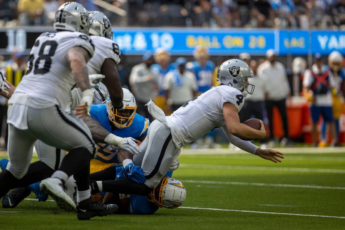 Los Angeles Chargers linebacker Khalil Mack (52) and linebacker Ty Shelby (59) sack Raiders qua ...