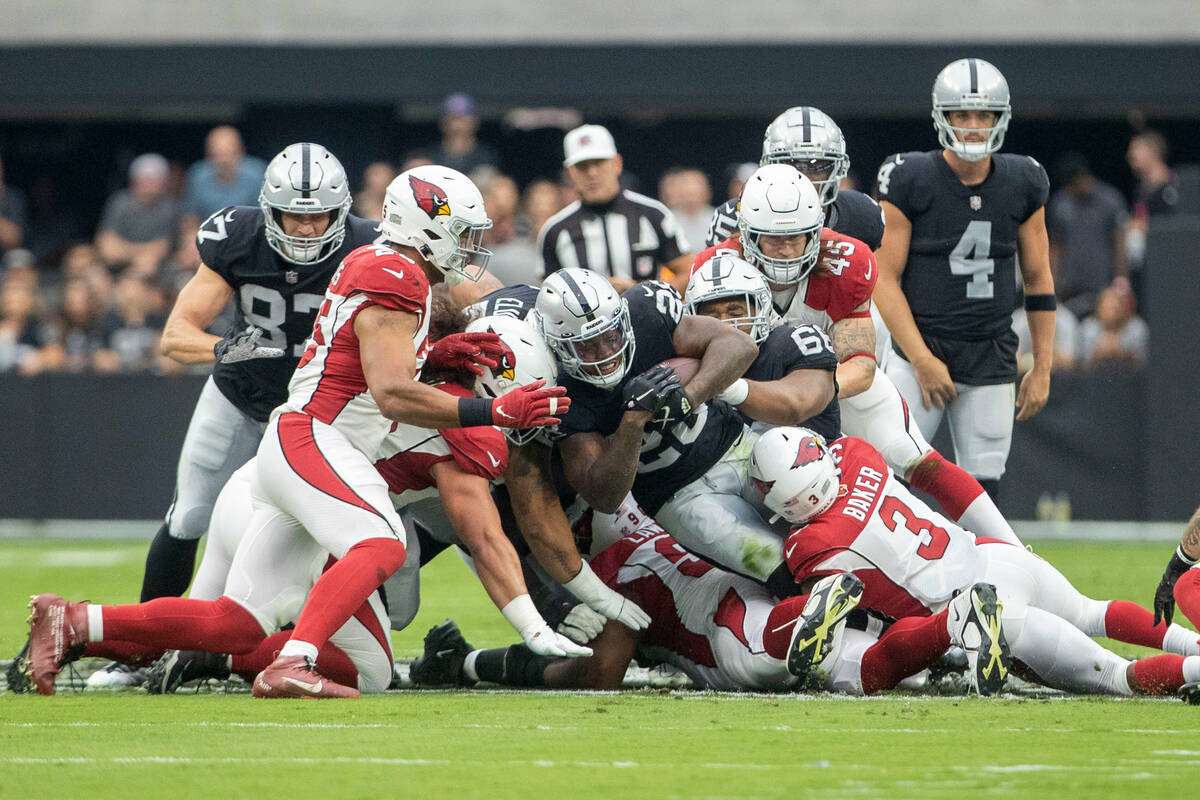 Raiders running back Josh Jacobs (28) is gang tackled as Arizona Cardinals safety Budda Baker ( ...