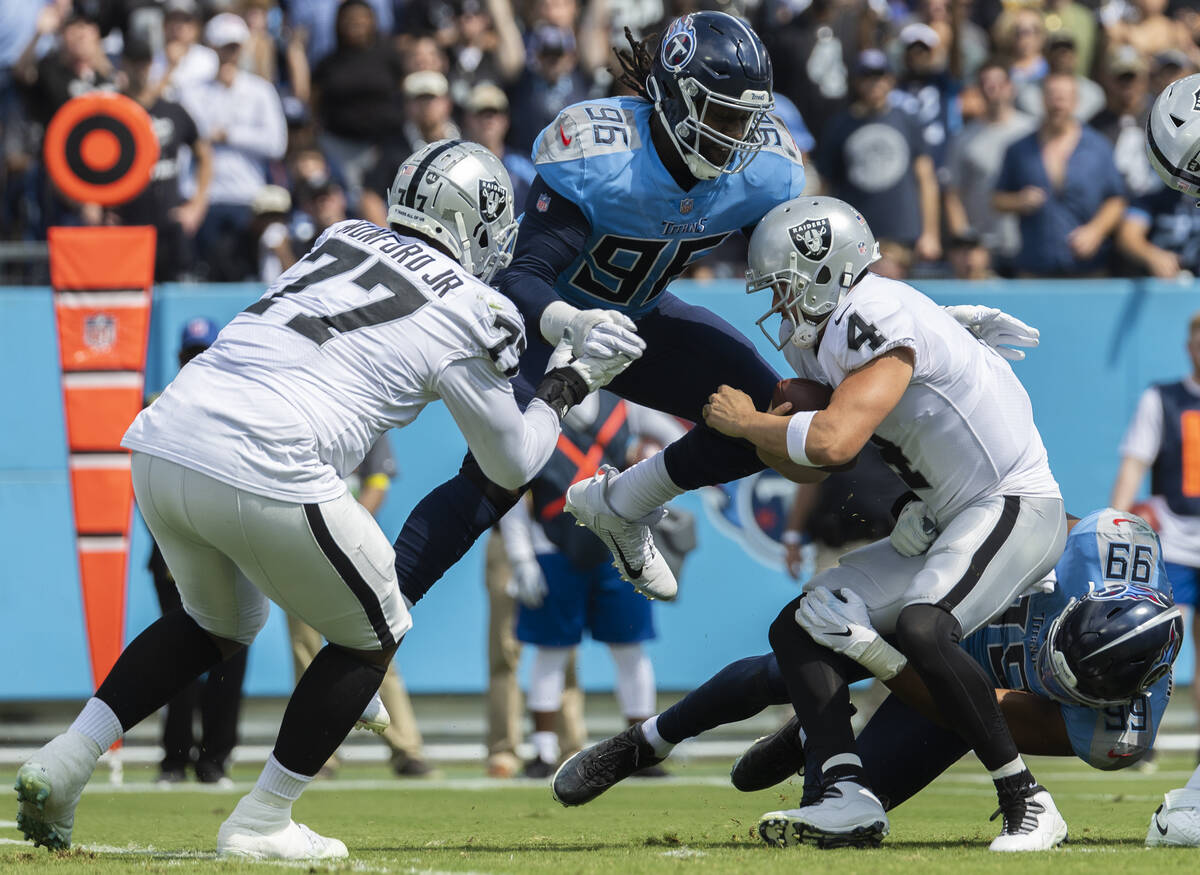 Raiders quarterback Derek Carr (4) is sacked by Tennessee Titans defensive end Denico Autry (96 ...