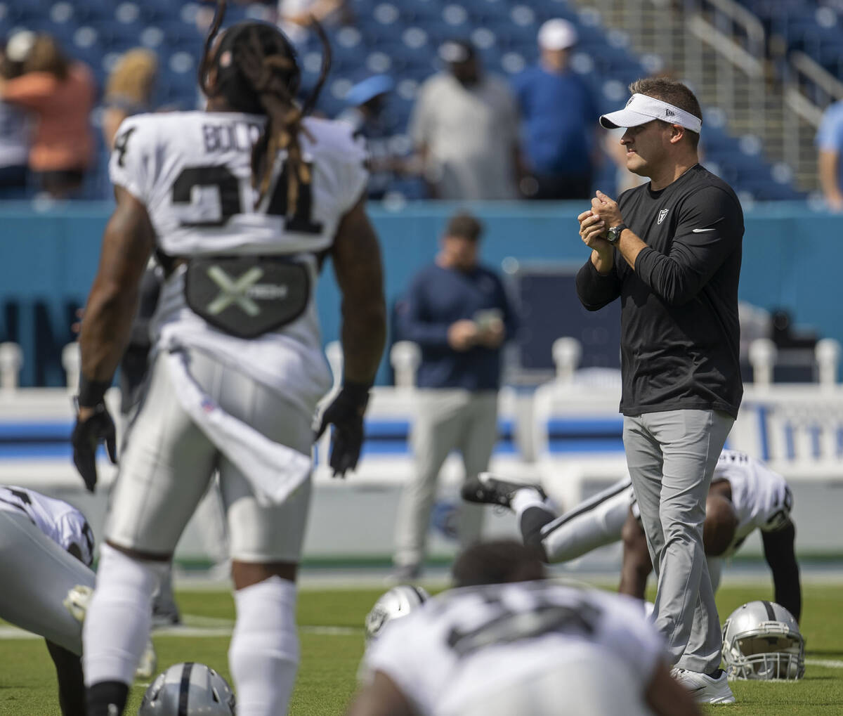 Raiders head coach Josh McDaniels watches team warm ups before an NFL game at Nissan Stadium ag ...