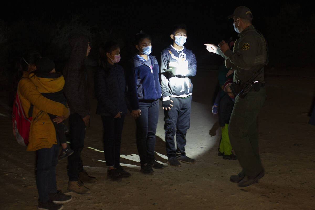 Migrants from Guatemala and Honduras are questioned by a Border Patrol agent after being smuggl ...