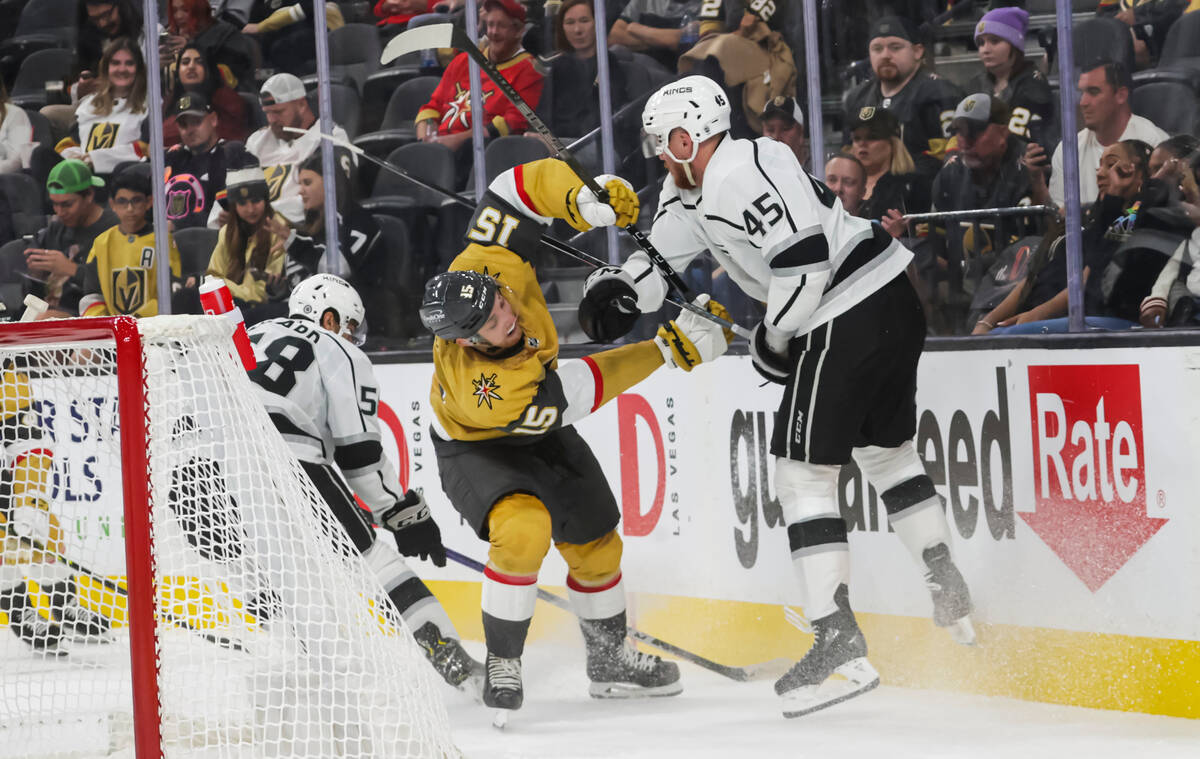 Golden Knights center Jake Leschyshyn (15) and Los Angeles Kings forward Jacob Doty (45) battle ...