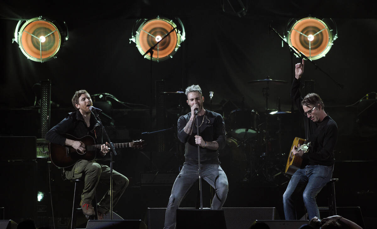 Adam Levine, center, and Jesse Carmichael, left, of the band Maroon 5 perform with Pearl Jam gu ...