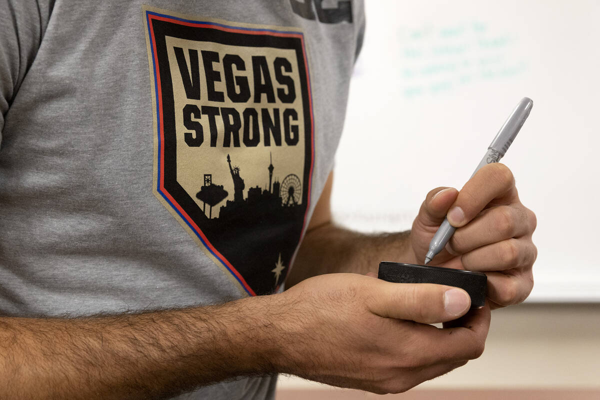 Golden Knights center Michael Amadio signs a puck for a fan at Metropolitan police’s 911 ...