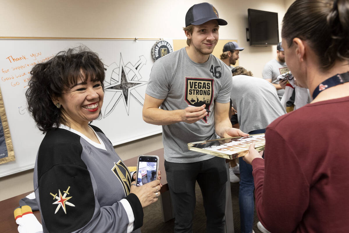 Golden Knights right wing Jonas Rondbjerg signs an autograph for a fan while 911 dispatcher Cas ...