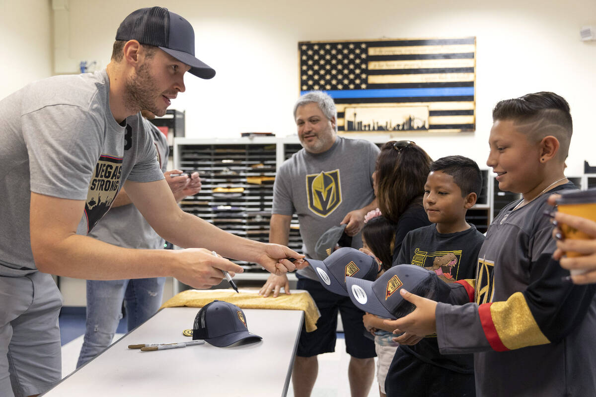 Golden Knights defenseman Brayden McNabb signs autographs for Hector Velarde Jr., 9, second fro ...