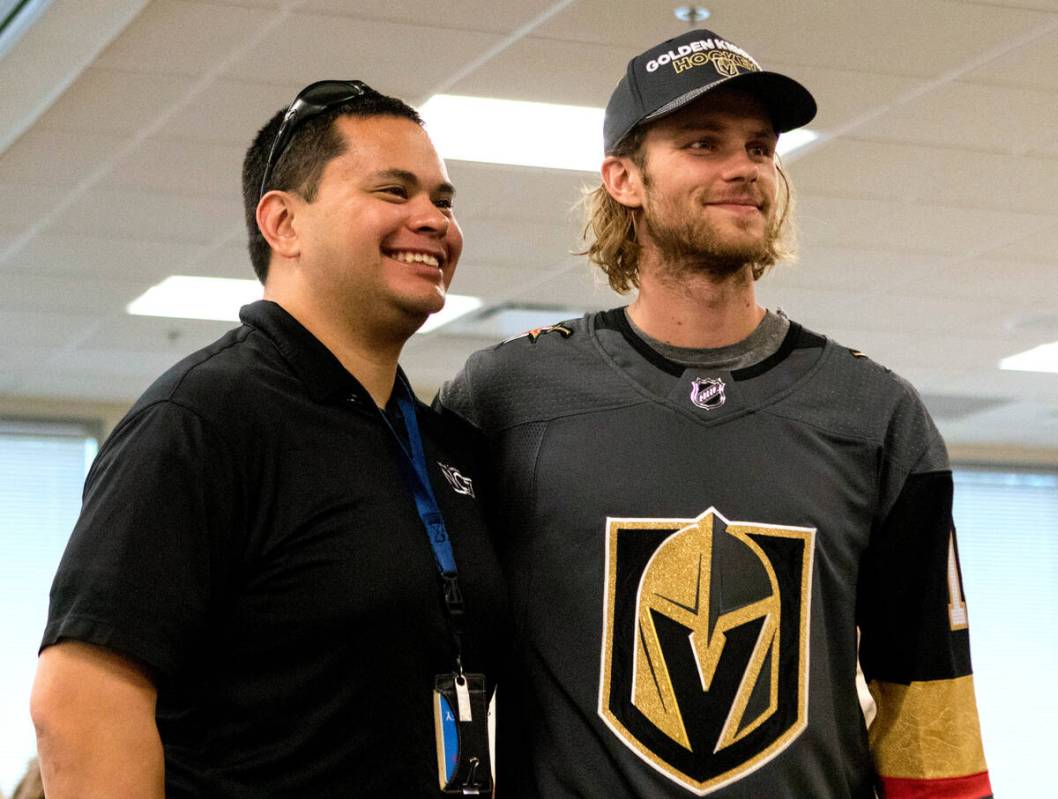 Metro detective Drew Krnjeu, left, with Vegas Golden Knights defenseman Jon Merrill (15) during ...